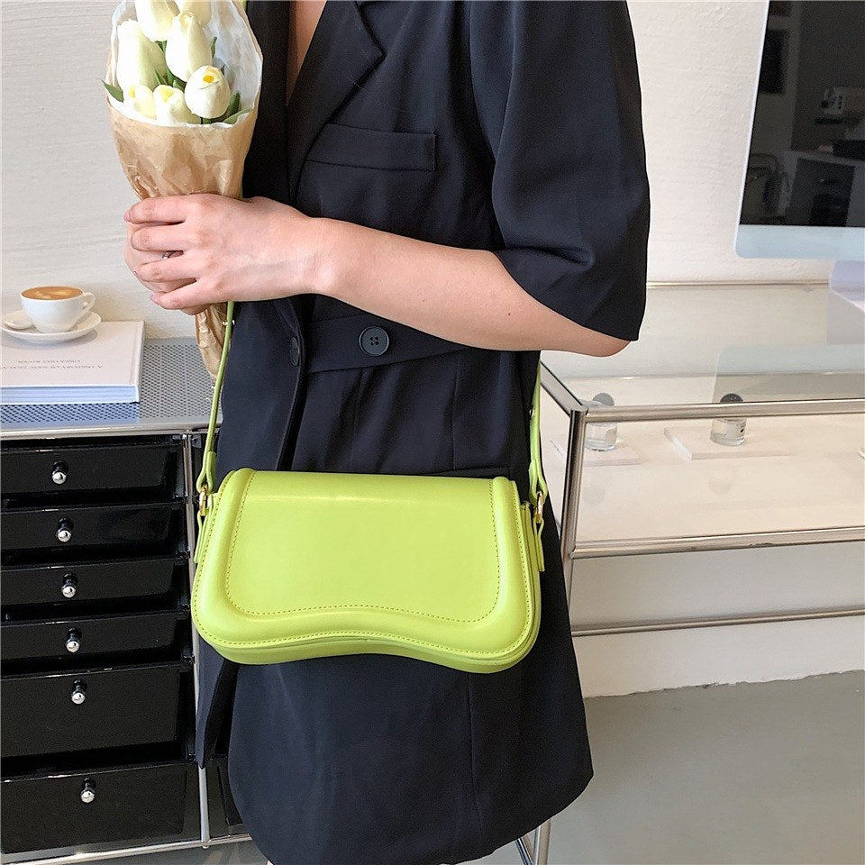 modelo com bolsa feminina de ombro verde clara